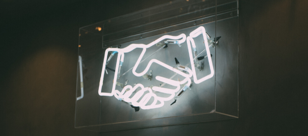 neon sign of hands shaking