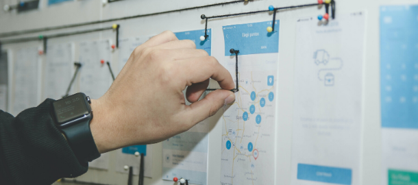 hand pinning string to a bulletin board