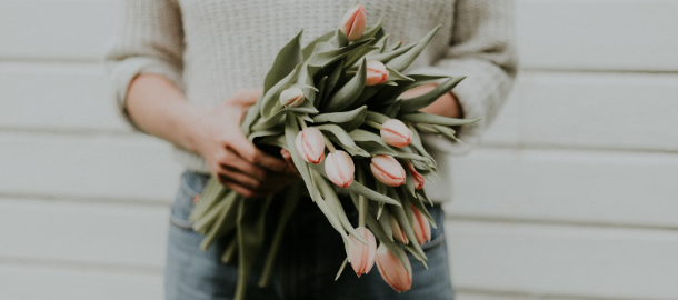 woman holding pink tulips